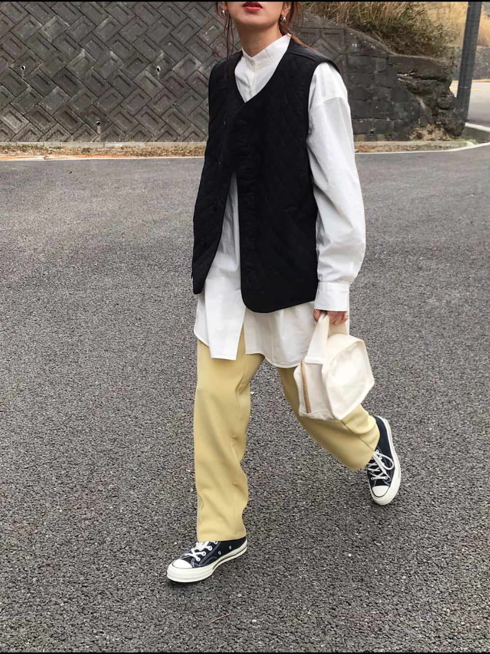 ホワイト系のシャツ/ブラウス、ブラック系のベスト、イエロー系のパンツを着用したレディースの冬コーディネートの1枚目の写真