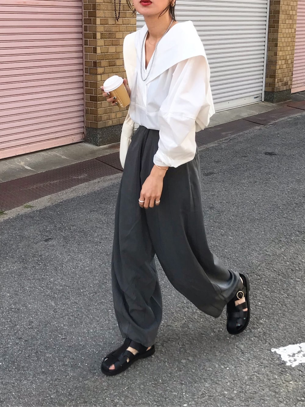 ホワイト系のシャツ/ブラウス、グレー系のスラックス、ホワイト系のバッグを着用したレディースの春コーディネートの1枚目の写真