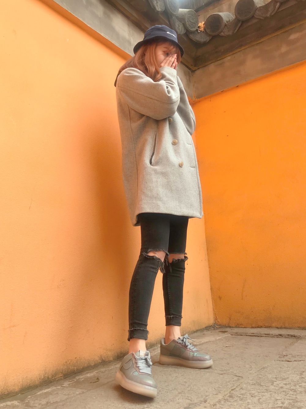 グレー系のピーコート、ブラック系のデニムパンツ、その他のスニーカーを着用したレディースの冬コーディネートの1枚目の写真