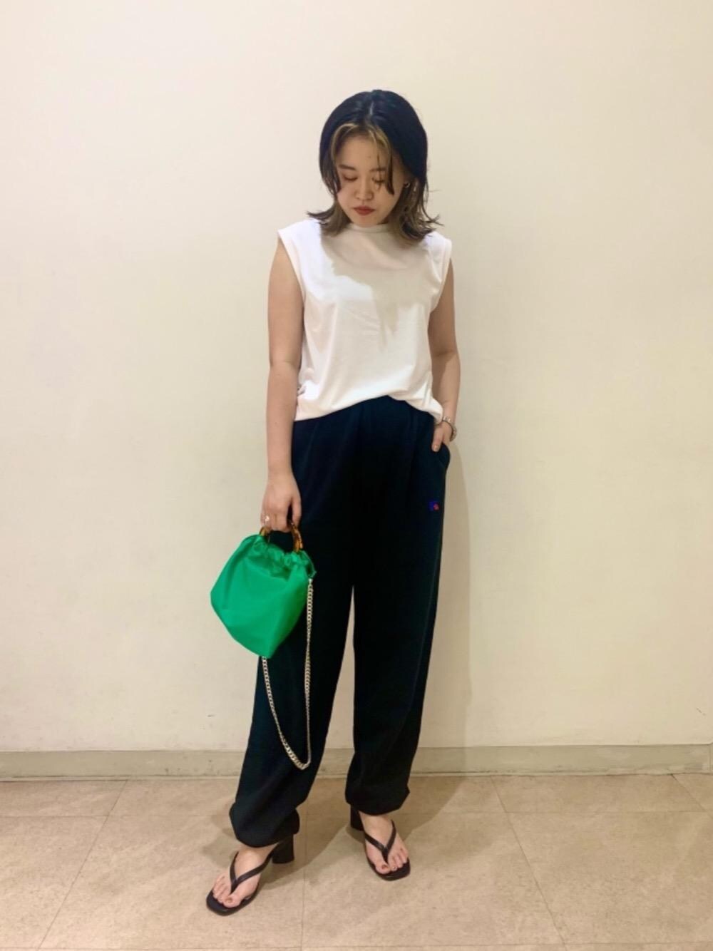 ブラック系のサンダル、ホワイト系のTシャツ/カットソー、グリーン系のショルダーバッグを着用したレディースの夏コーディネートの1枚目の写真