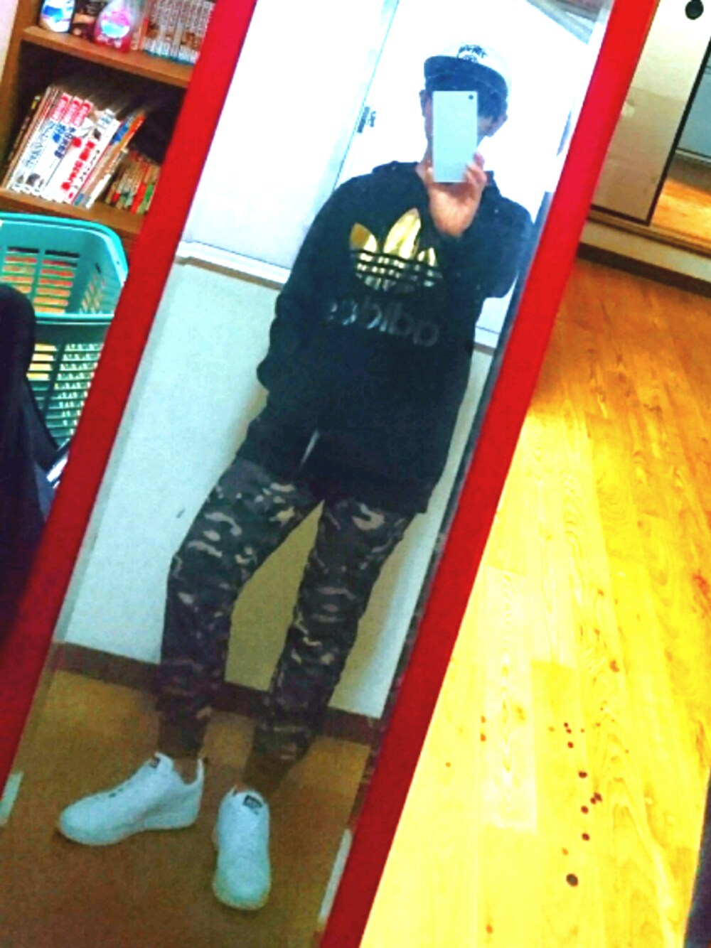 ブラック系のパーカー、ホワイト系のスニーカー、ホワイト系のキャップを着用したメンズの冬コーディネートの1枚目の写真