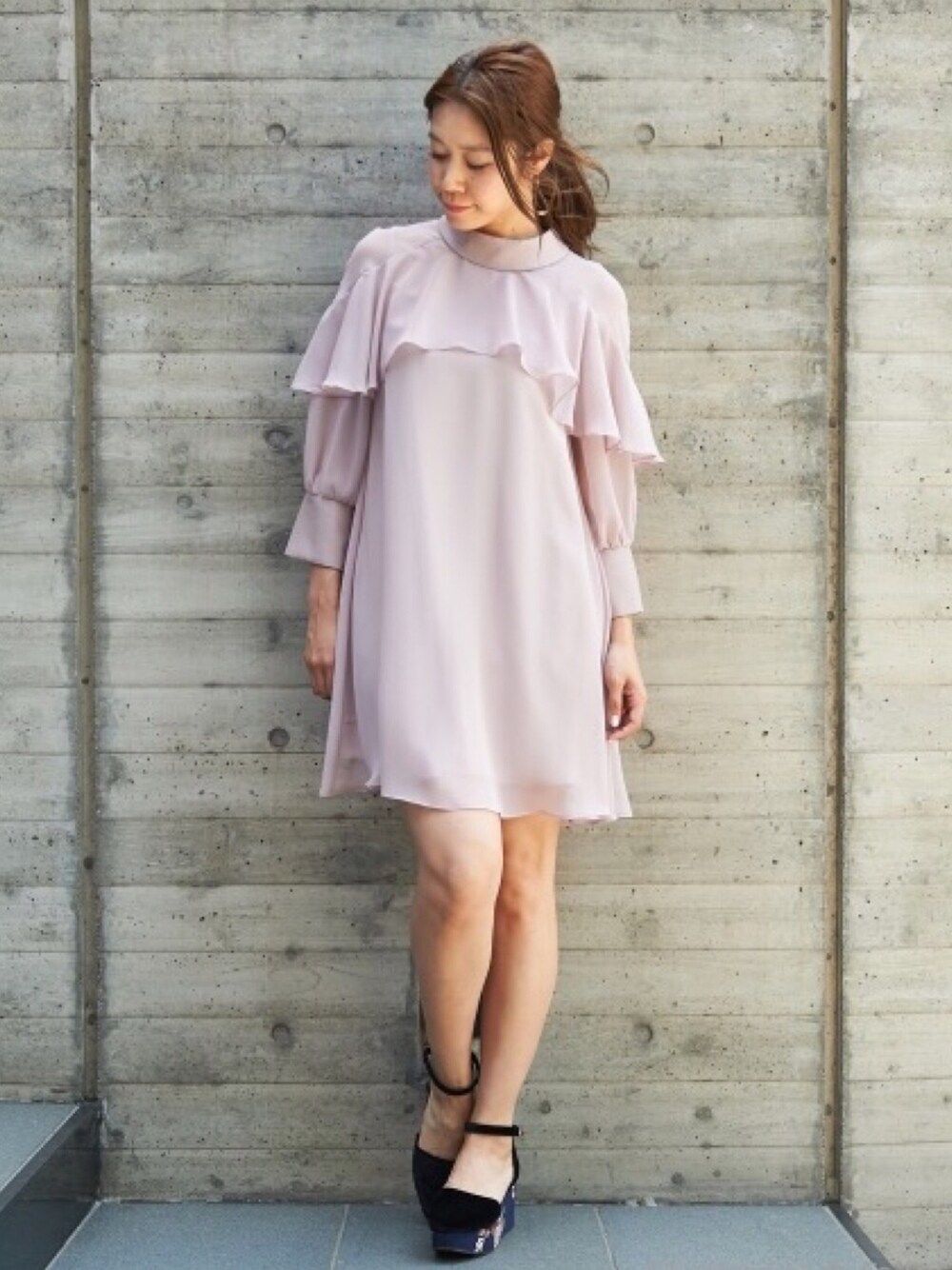 ブラック系のパンプス、ピンク系のワンピースを着用したレディースの秋コーディネートの1枚目の写真