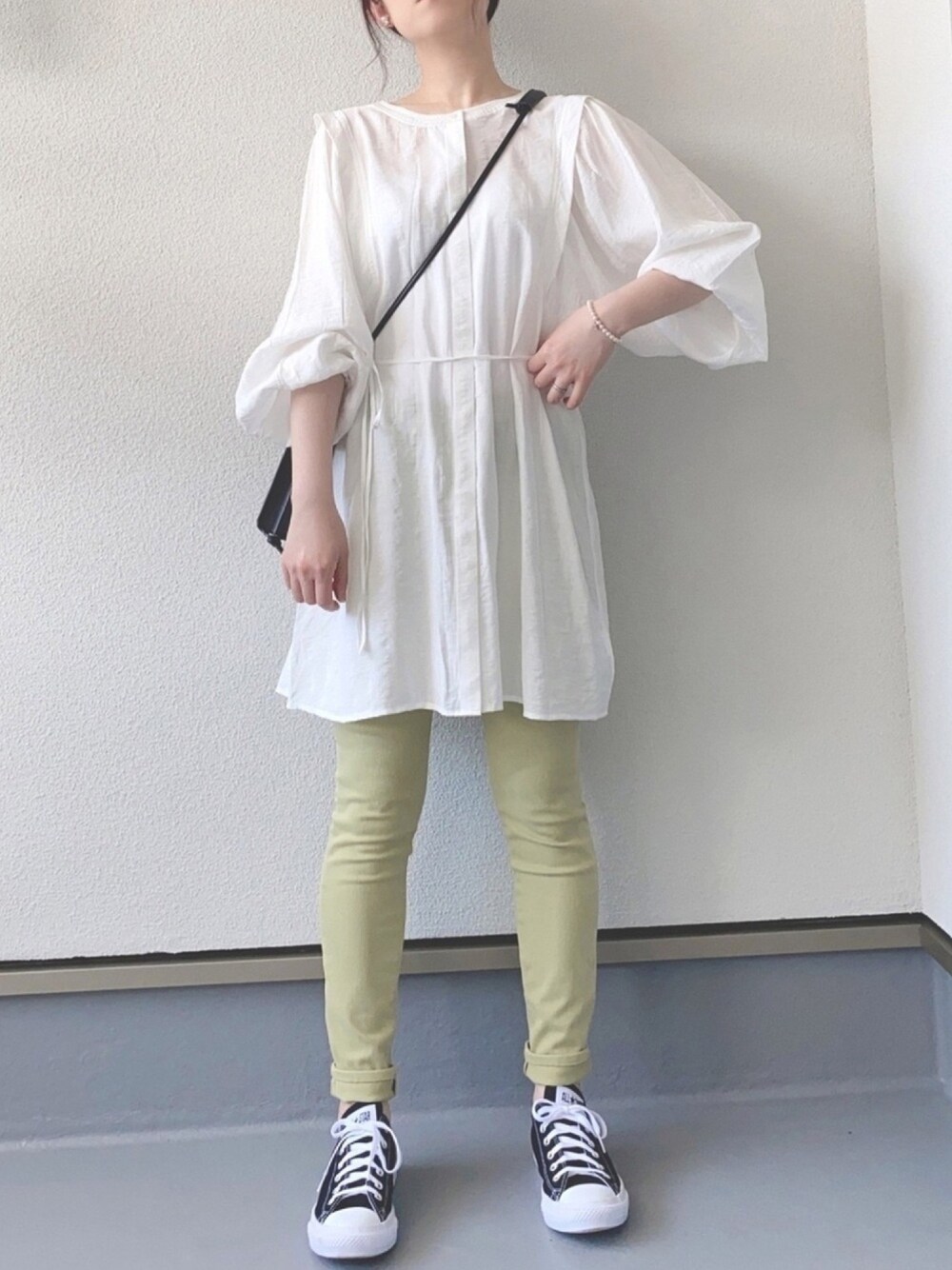 ホワイト系のシャツ/ブラウス、グリーン系のパンツ、ブラック系のスニーカーを着用したレディースの春コーディネートの1枚目の写真