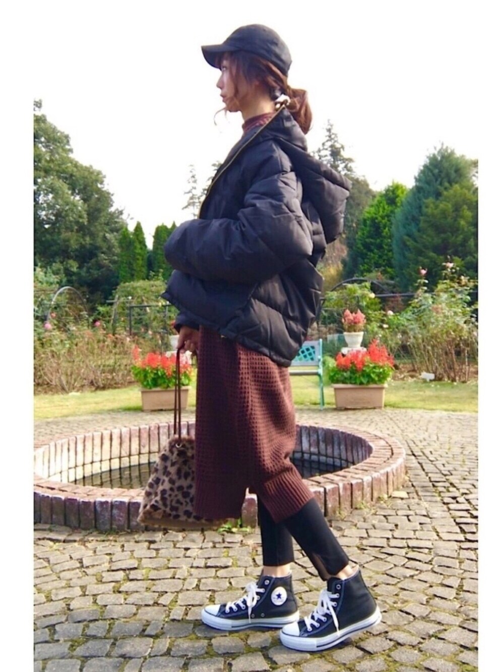 ブラウン系のショルダーバッグ、ブラウン系のワンピース、ブラック系のスニーカーを着用したレディースの秋コーディネートの1枚目の写真