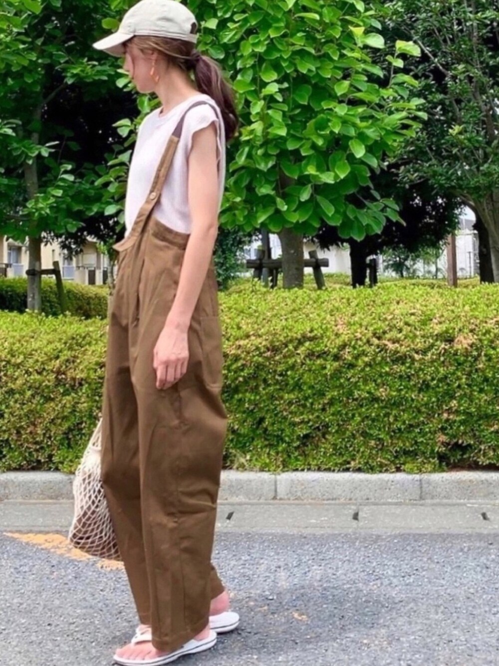 ブラウン系のサロペット/オーバーオール、ベージュ系のTシャツ/カットソー、ベージュ系のショルダーバッグを着用したレディースの夏コーディネートの1枚目の写真