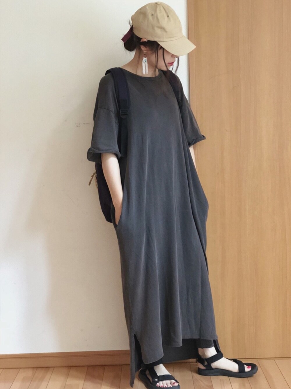 ブラック系のサンダル、グレー系のワンピース、ブルー系のバックパック/リュックを着用したレディースの春コーディネートの1枚目の写真