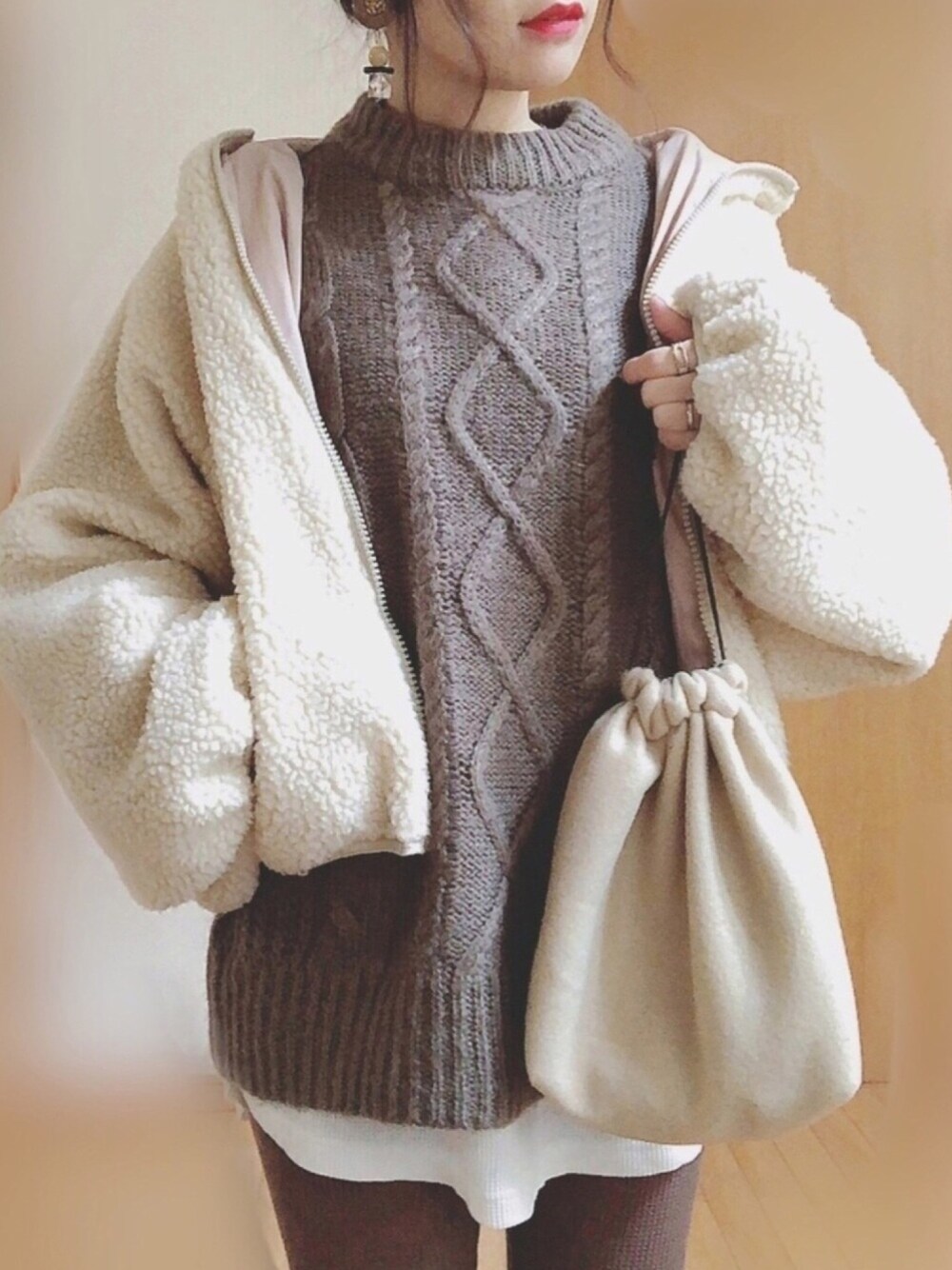 ベージュ系のブルゾン、ベージュ系のバッグ、ホワイト系のTシャツ/カットソーを着用したレディースの冬コーディネートの1枚目の写真