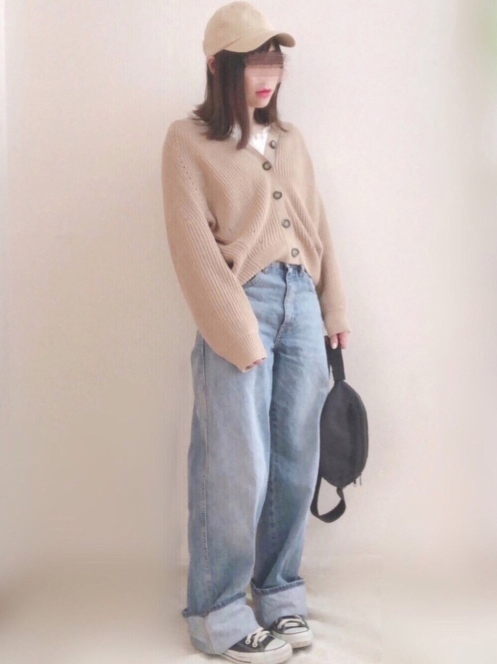 ブルー系のデニムパンツ、ベージュ系のカーディガン/ボレロ、ブラック系のスニーカーを着用したレディースの春コーディネートの1枚目の写真