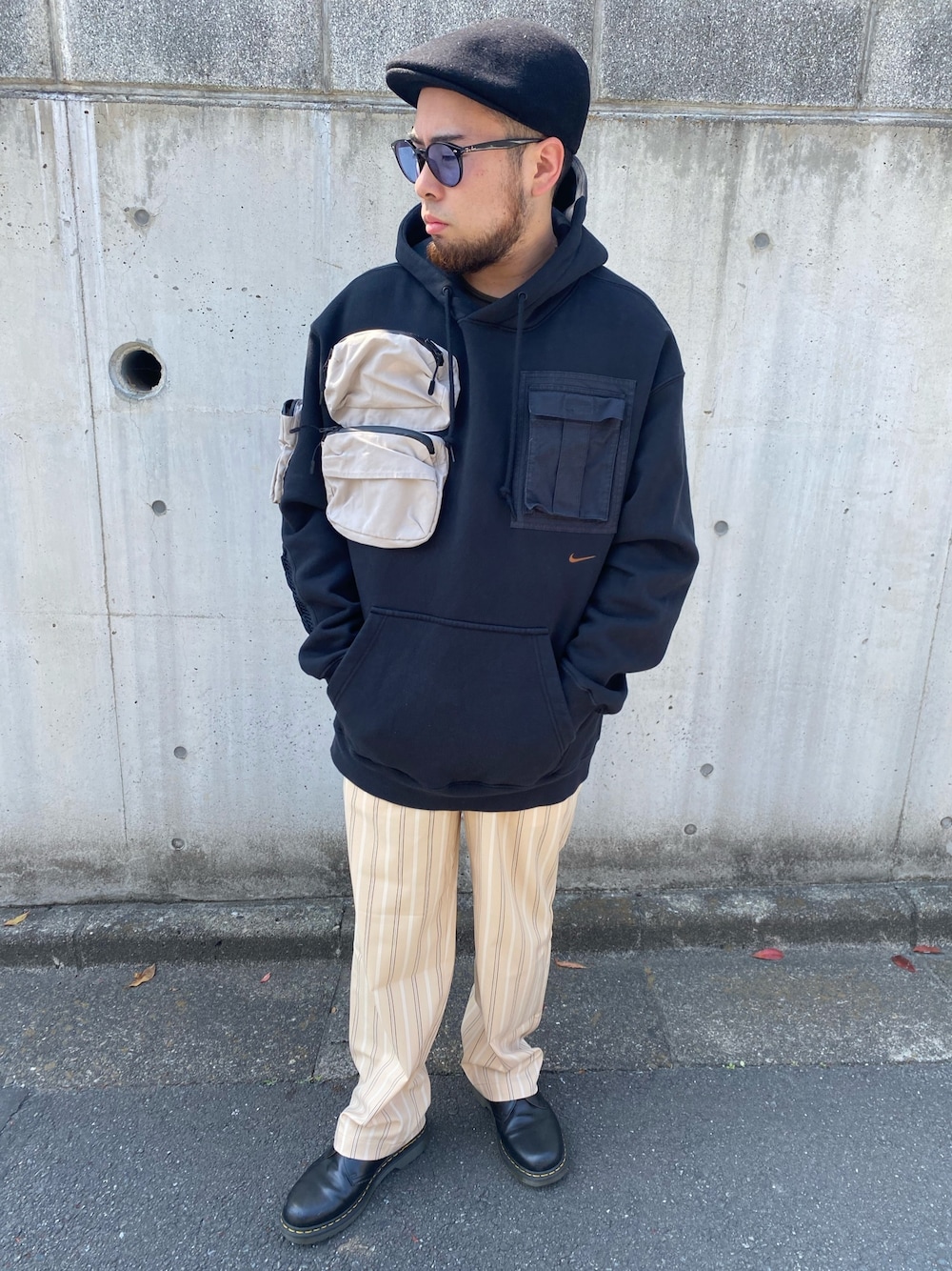 ブラック系のパーカー、ベージュ系のパンツ、ブラック系のドレスシューズを着用したメンズの春コーディネートの1枚目の写真