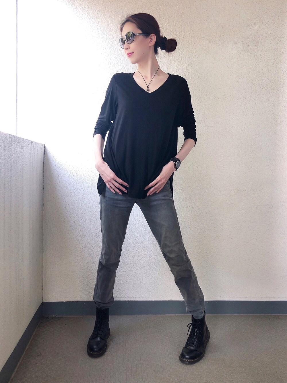 グレー系のデニムパンツ、ブラック系のブーツ、ブラック系のTシャツ/カットソーを着用したレディースの春コーディネートの1枚目の写真