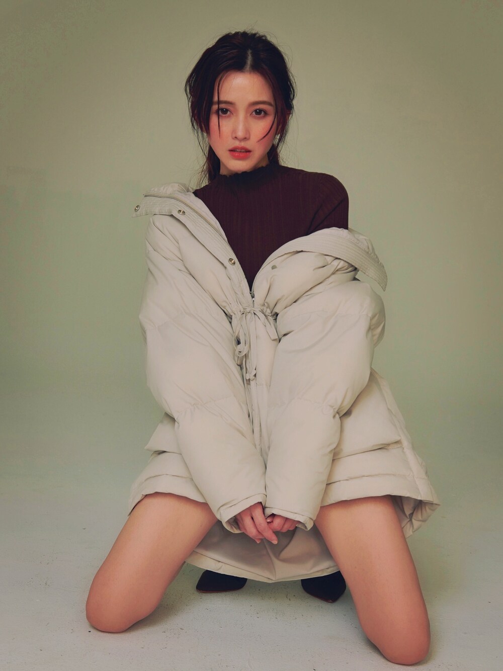 ベージュ系のダウンジャケット/コート、ブラウン系のニット/セーターを着用したレディースの秋コーディネートの1枚目の写真