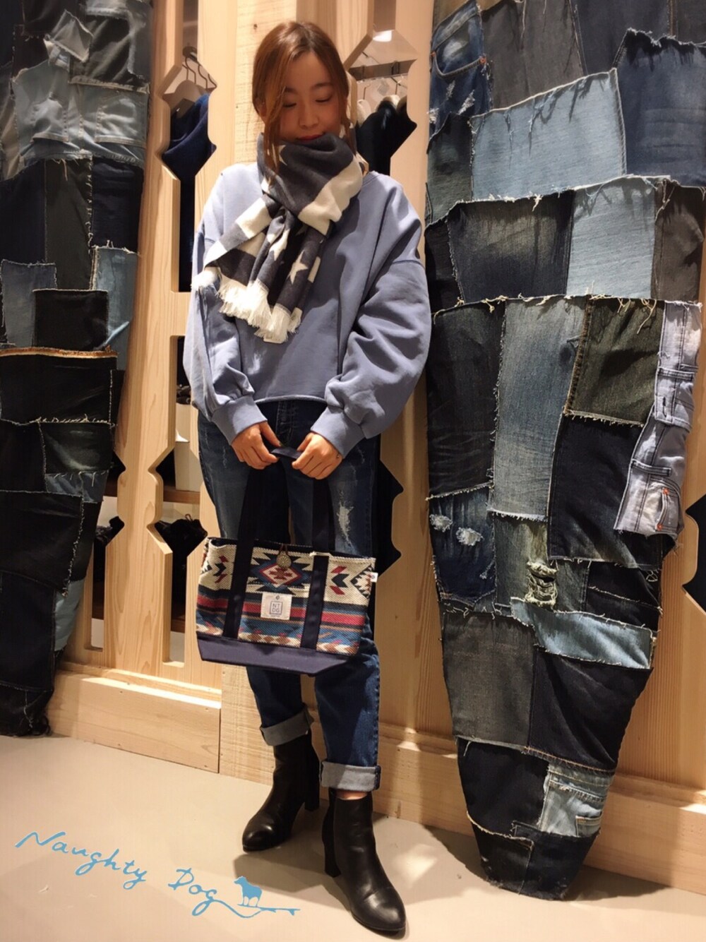 ブルー系のスウェット、ブルー系のデニムパンツ、ブルー系のトートバッグを着用したレディースの冬コーディネートの1枚目の写真