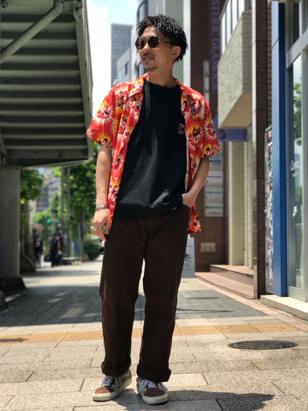 レッド系のシャツ/ブラウス、ブラック系のTシャツ/カットソー、ブラウン系のチノパンツを着用したメンズの夏コーディネートの1枚目の写真