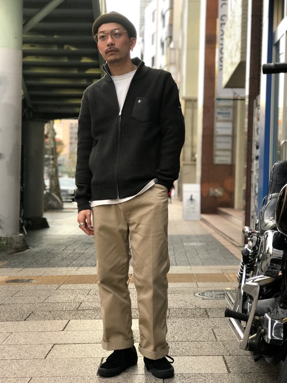 グリーン系のカーディガン/ボレロ、ホワイト系のTシャツ/カットソー、ベージュ系のチノパンツを着用したメンズの秋コーディネートの1枚目の写真