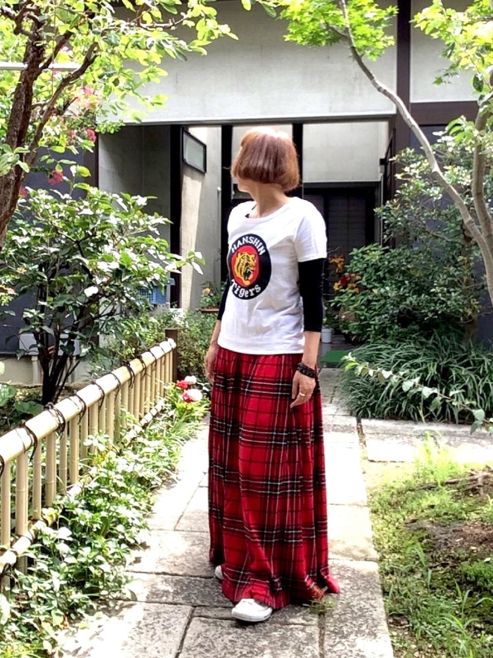 レッド系のスカートを着用したレディースの秋コーディネートの1枚目の写真