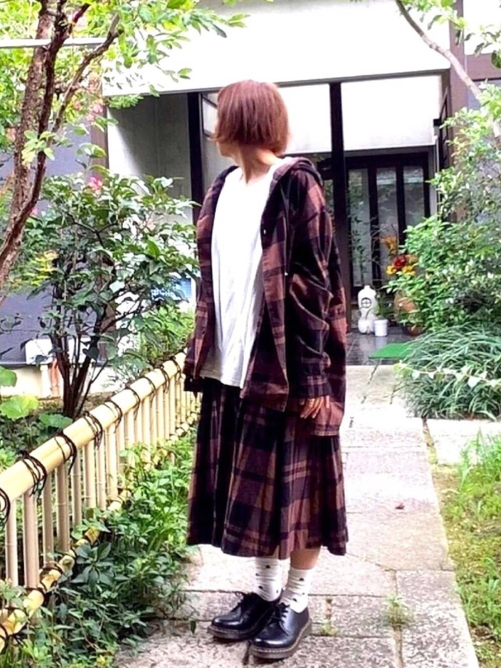 ブラック系のドレスシューズ、ブラウン系のシャツ/ブラウス、ブラウン系のスカートを着用したレディースの秋コーディネートの1枚目の写真