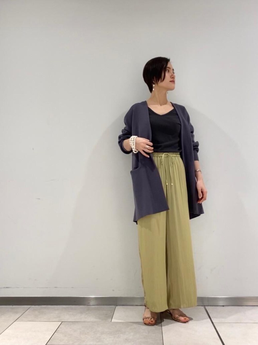グレー系のカーディガン/ボレロ、グレー系のタンクトップ、イエロー系のその他パンツを着用したレディースの春コーディネートの1枚目の写真