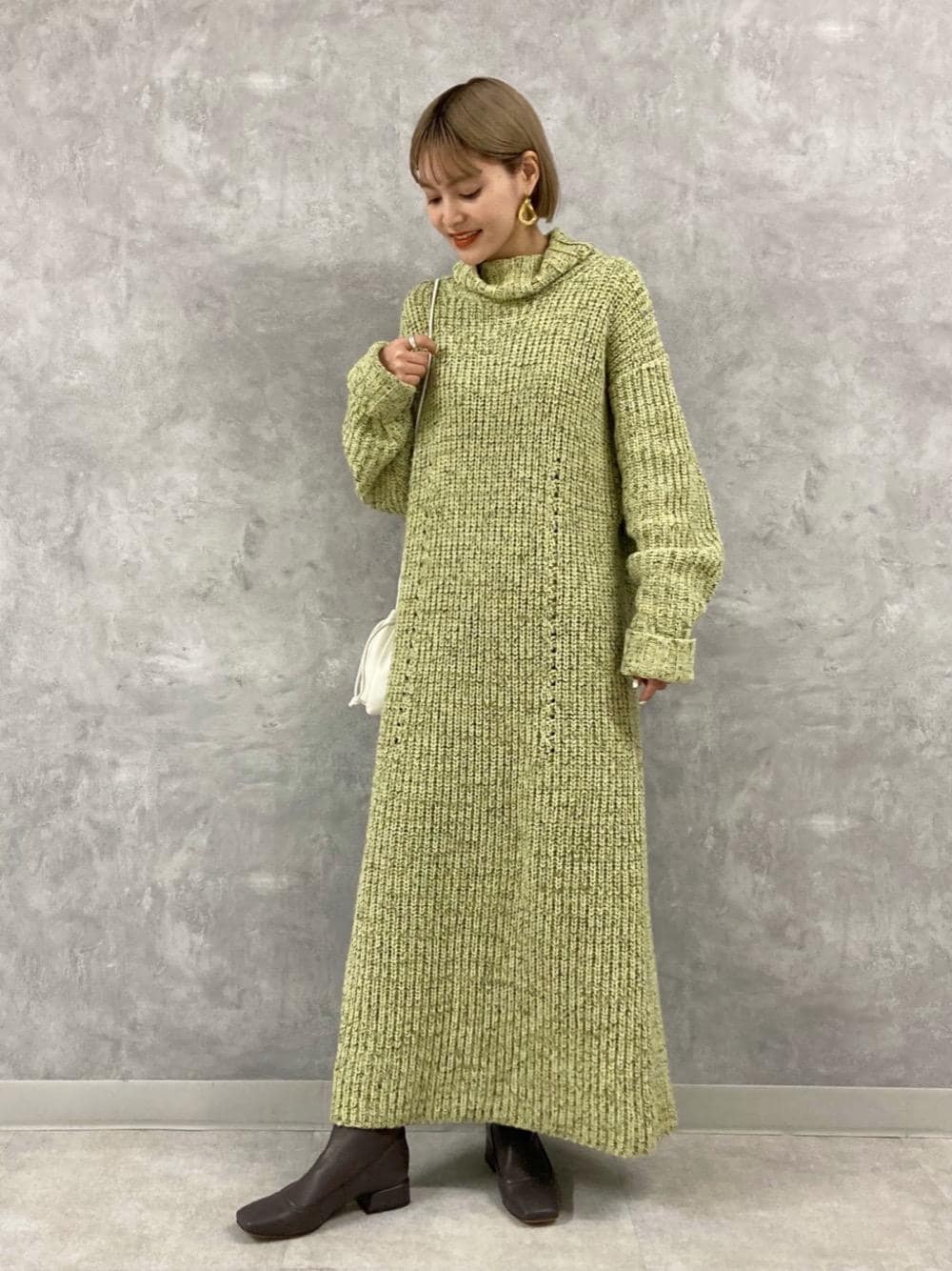 「グリーン、ショートブーツ、冬コーデ、ニットワンピース、タートルネック、オデットエオディール、Boots styling、Skirt style、休日すたいる」｜「ODETTE E ODILEの＜ESLOW(エスロー)＞ DRAWSTRING BAG（ショルダーバッグ、ホワイト系）」を使った、稲垣　オデット エ オディール スタッフさん（レディース・157cm）の冬コーディネートの1枚目の写真