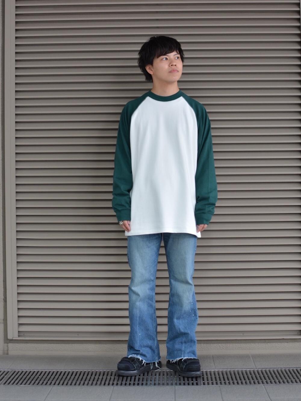 グリーン系のTシャツ/カットソーを着用したメンズの秋コーディネートの1枚目の写真