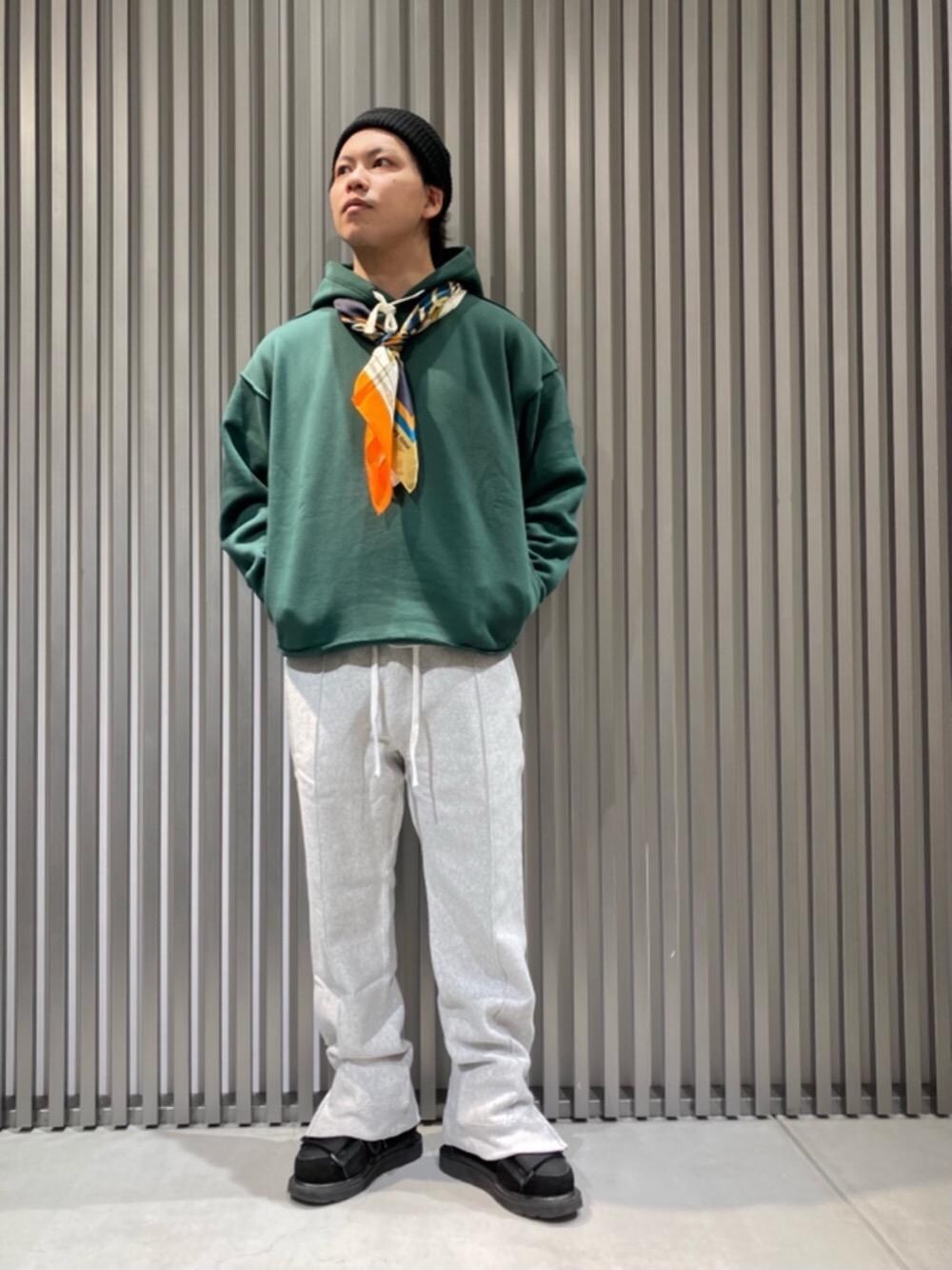 グレー系のスウェットパンツ、グリーン系のパーカー、ブルー系のマフラーを着用したメンズの秋コーディネートの1枚目の写真