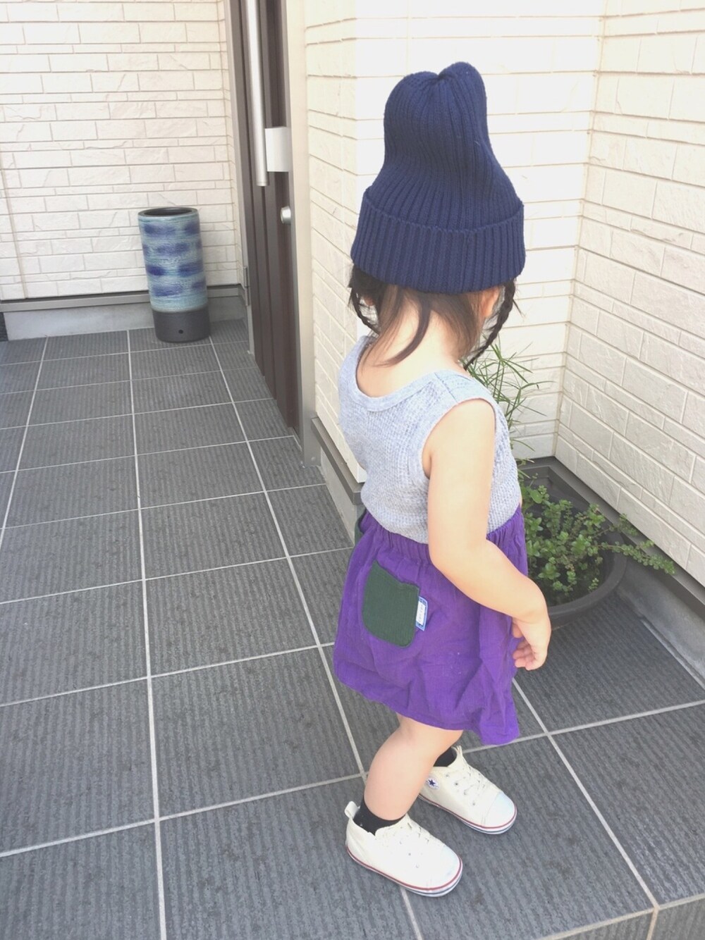 グレー系のタンクトップ、パープル系のスカート、ホワイト系のスニーカーを着用したキッズの夏コーディネートの1枚目の写真