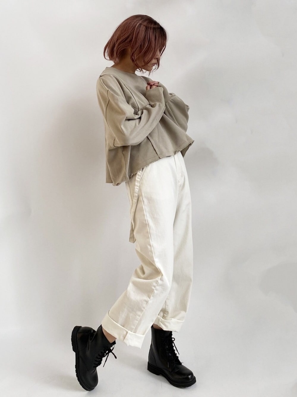 ブラック系のデニムパンツ、グリーン系のTシャツ/カットソー、ブラック系のブーツを着用したレディースの秋コーディネートの1枚目の写真