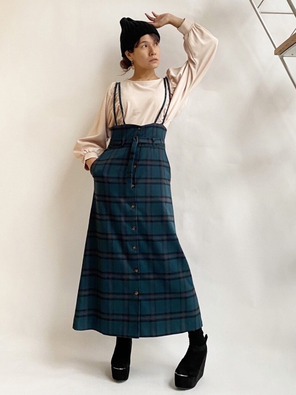 ホワイト系のTシャツ/カットソー、グリーン系のジャンパースカート、ブラック系のサンダルを着用したレディースの秋コーディネートの1枚目の写真