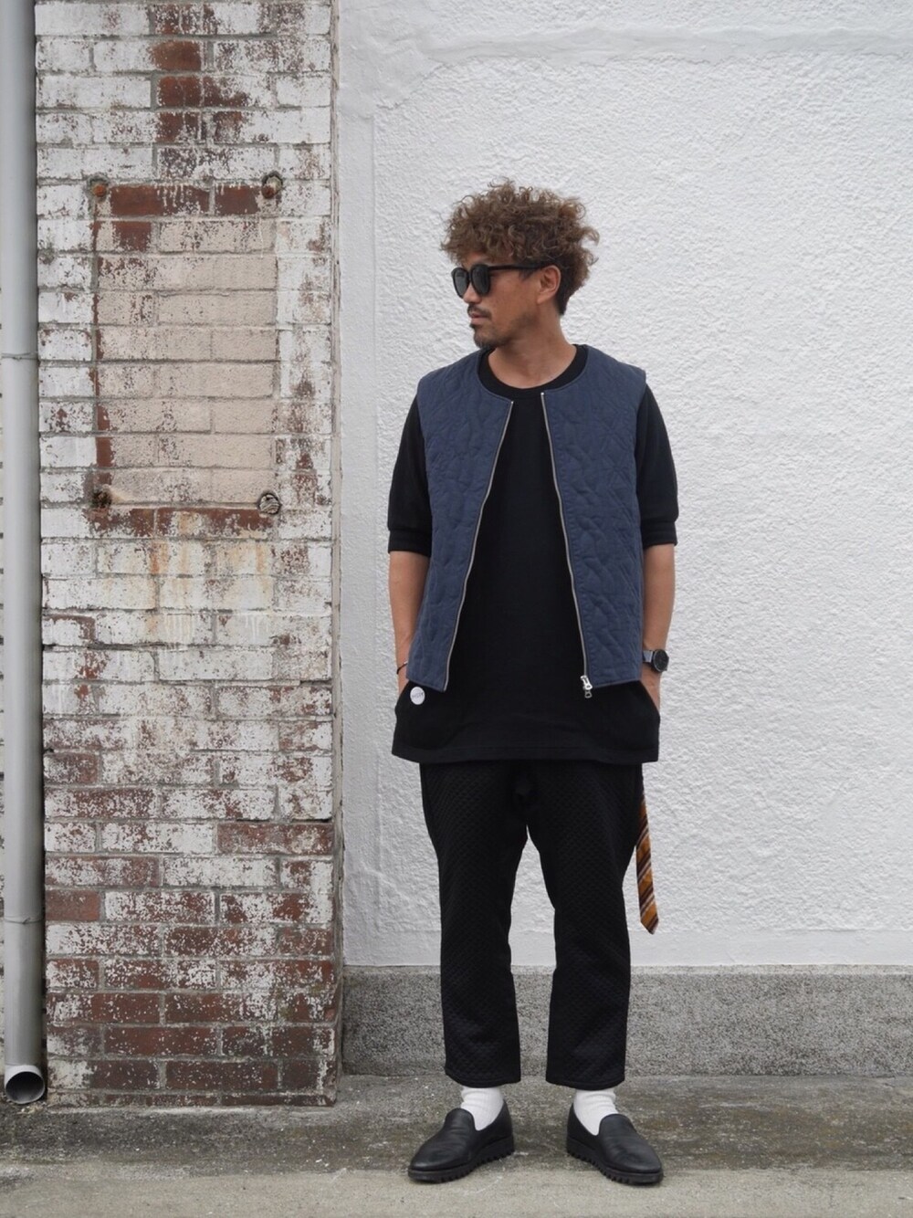 ブルー系のベスト、ブラック系のTシャツ/カットソー、ブラック系のその他パンツを着用したメンズの秋コーディネートの1枚目の写真