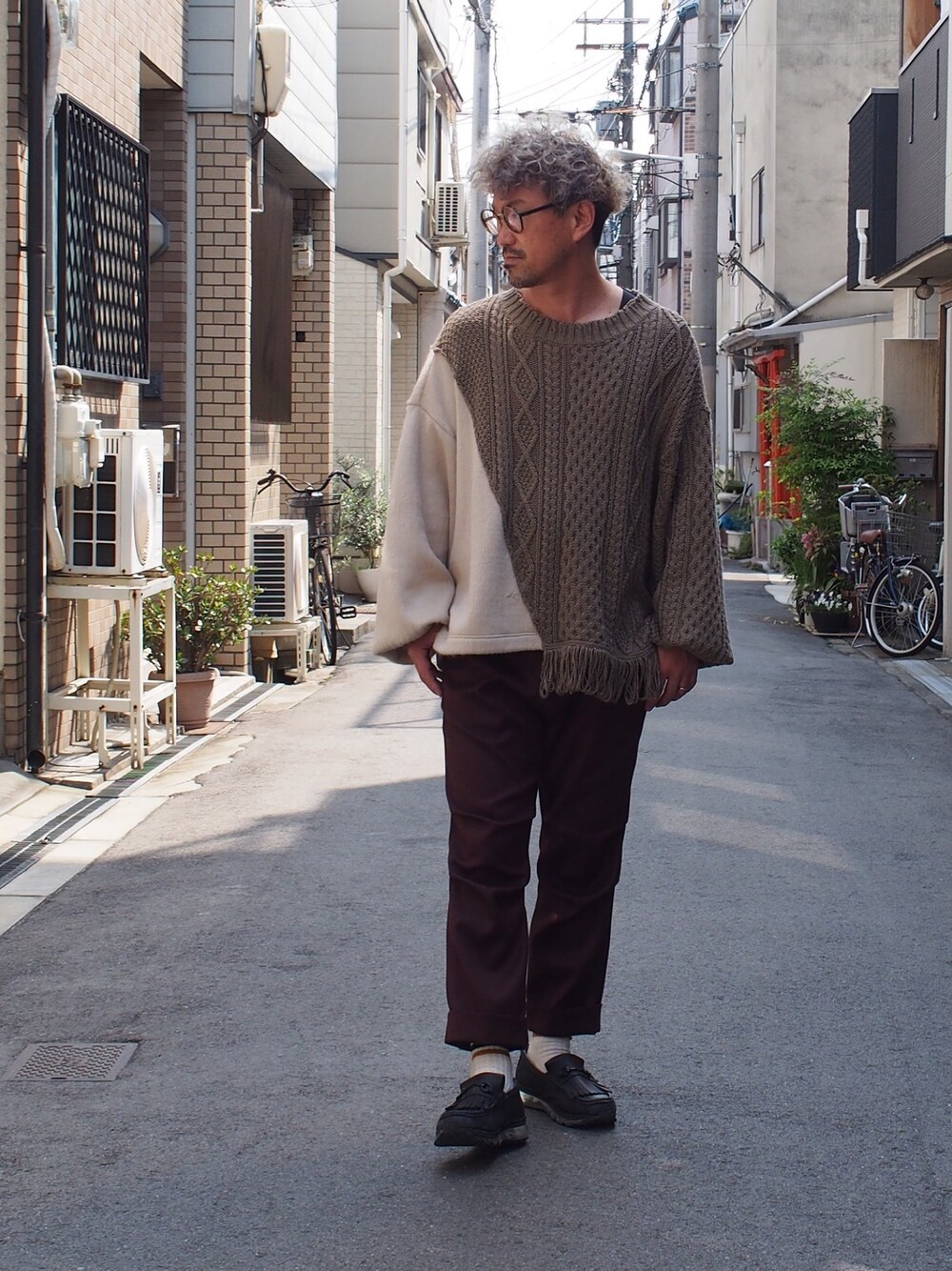 ベージュ系のニット/セーター、ブラウン系のスラックスを着用したメンズの春コーディネートの1枚目の写真