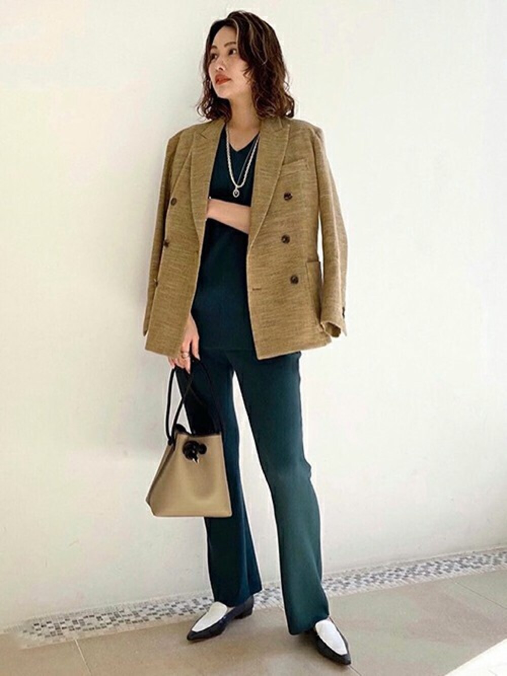 イエロー系のテーラードジャケット、グリーン系のニット/セーター、グリーン系のその他パンツを着用したレディースの春コーディネートの1枚目の写真