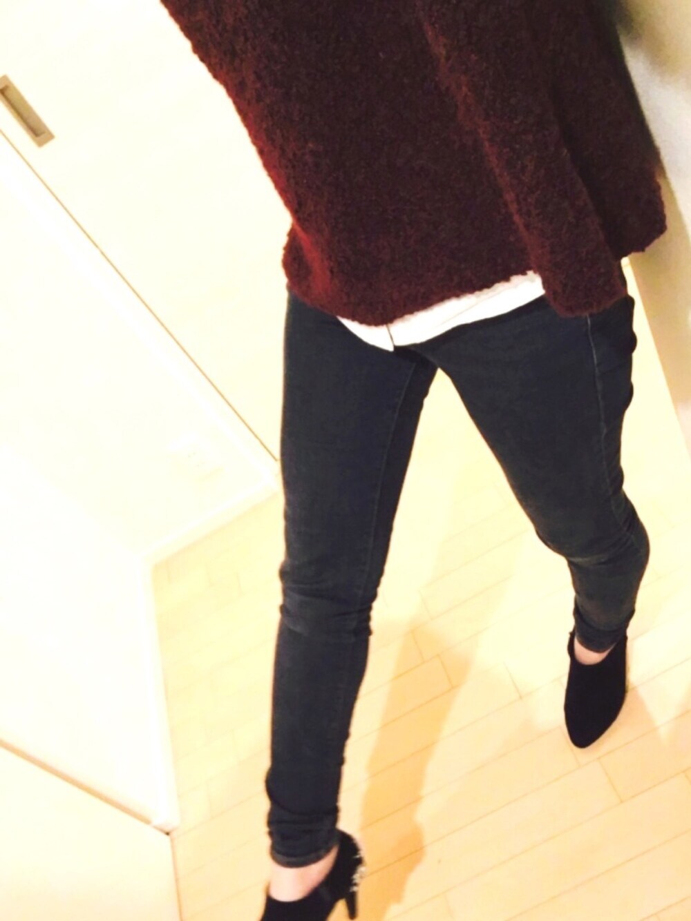 ブルー系のデニムパンツ、レッド系のニット/セーター、ブルー系のパンプスを着用したレディースの冬コーディネートの1枚目の写真