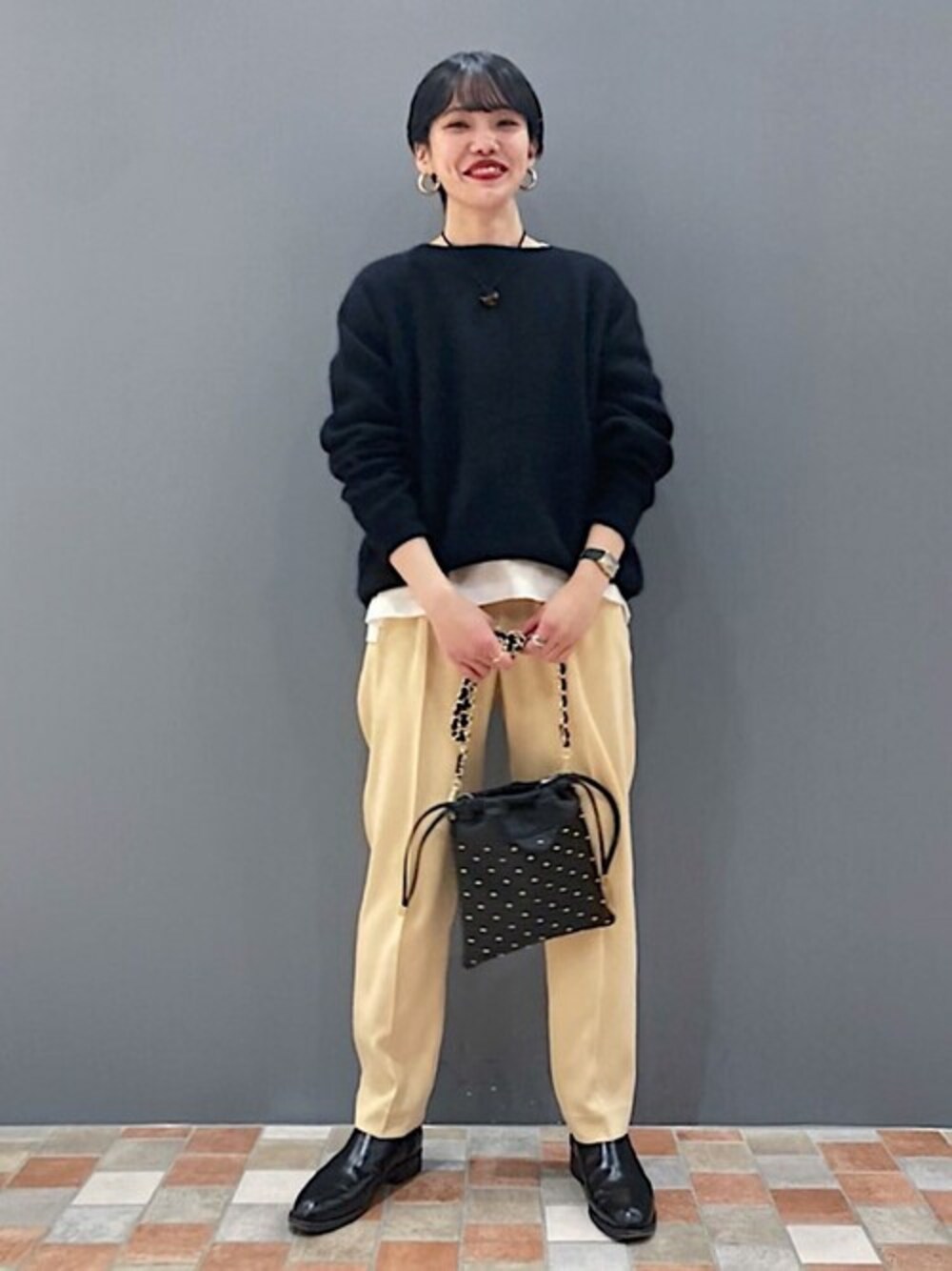 「ニット、イエロー、冬コーデ、大人カジュアル、サテンパンツ、巾着バッグ、SHIPS for women、スタッズバッグ」｜「SHIPSのMilos:スタッズ巾着ポシェット◇（ショルダーバッグ、ブラック系）」を使った、伊藤さん（レディース・156cm）の冬コーディネートの1枚目の写真