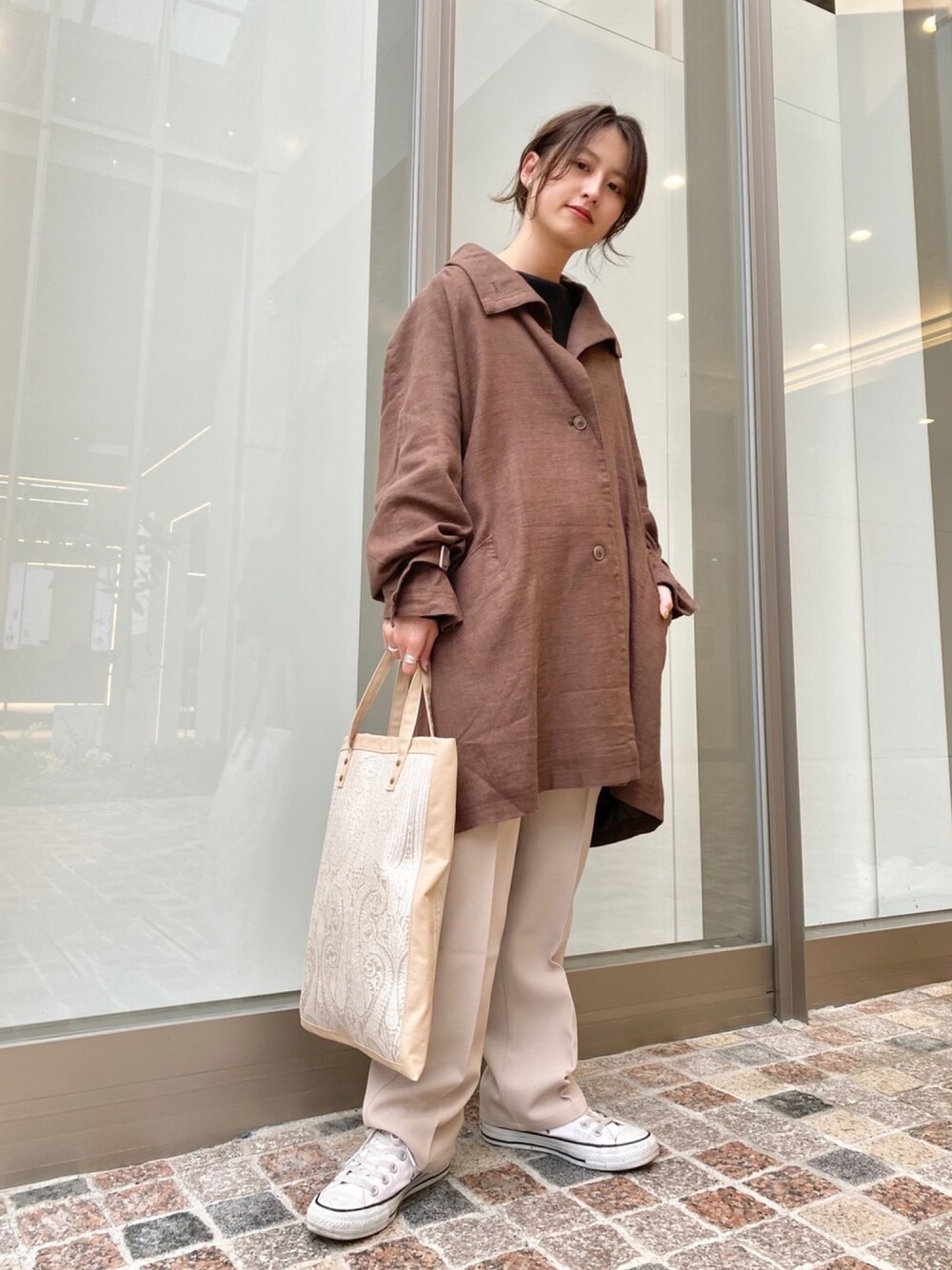 ブラウン系のその他アウター、ブラック系のTシャツ/カットソー、ベージュ系のトートバッグを着用したレディースの春コーディネートの1枚目の写真