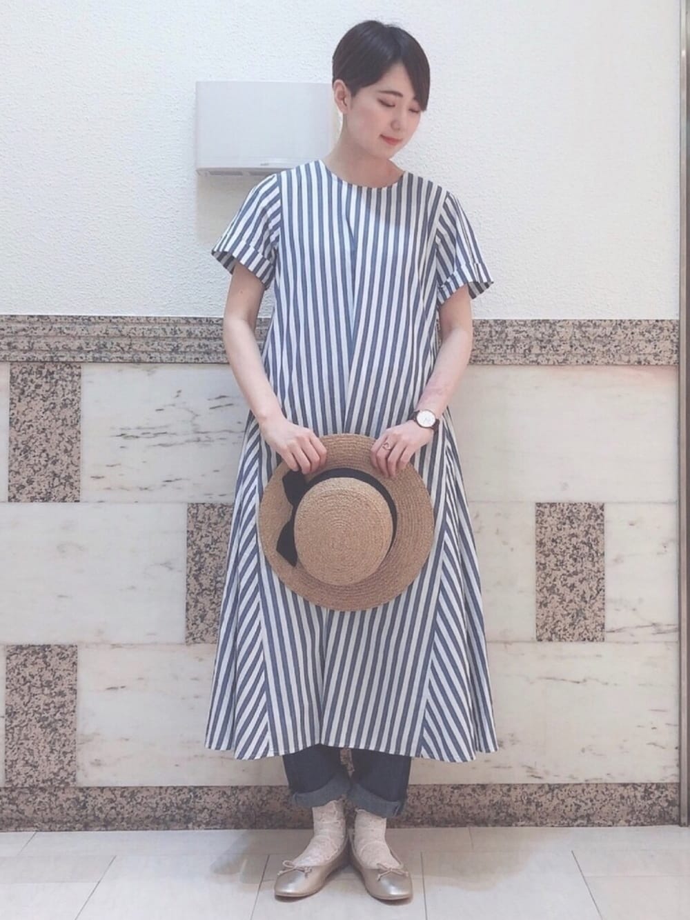 ブルー系のワンピース、ブルー系のデニムパンツ、ゴールド系のバレエシューズを着用したレディースの春コーディネートの1枚目の写真