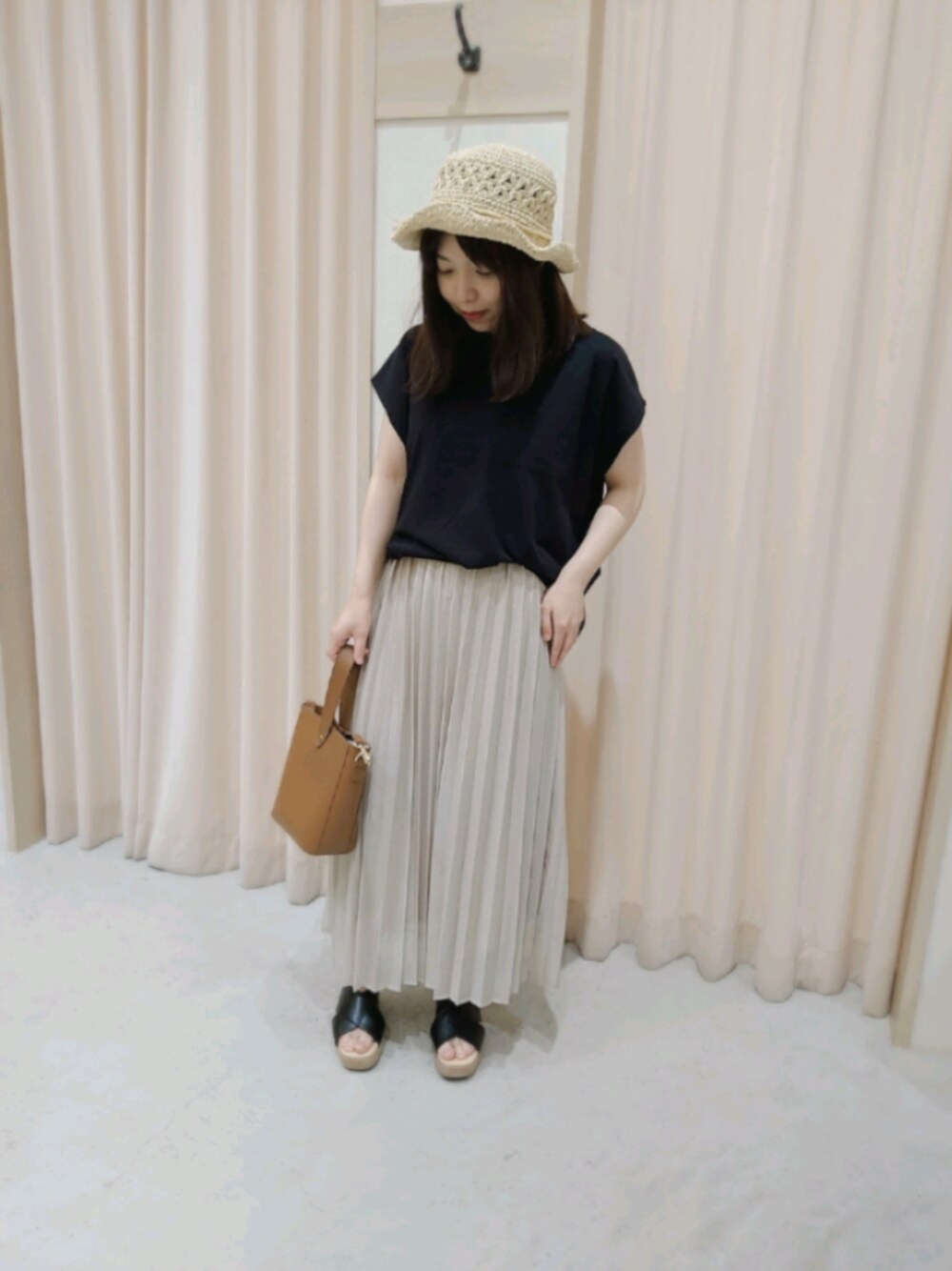 パープル系のスカート、ブラック系のサンダル、ブラック系のTシャツ/カットソーを着用したレディースの春コーディネートの1枚目の写真