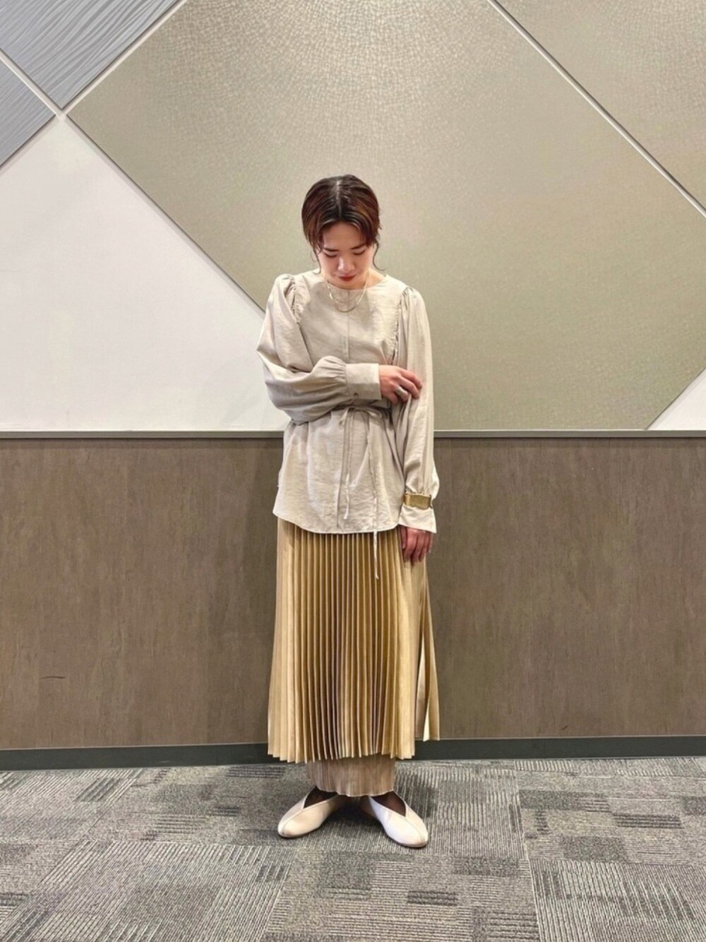 ベージュ系のTシャツ/カットソー、ベージュ系のスカート、ベージュ系のスカートを着用したレディースの冬コーディネートの1枚目の写真