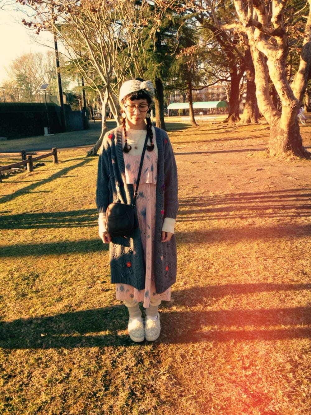 ブラウン系のショルダーバッグ、ピンク系のワンピース、グレー系のカーディガン/ボレロを着用したレディースの冬コーディネートの1枚目の写真