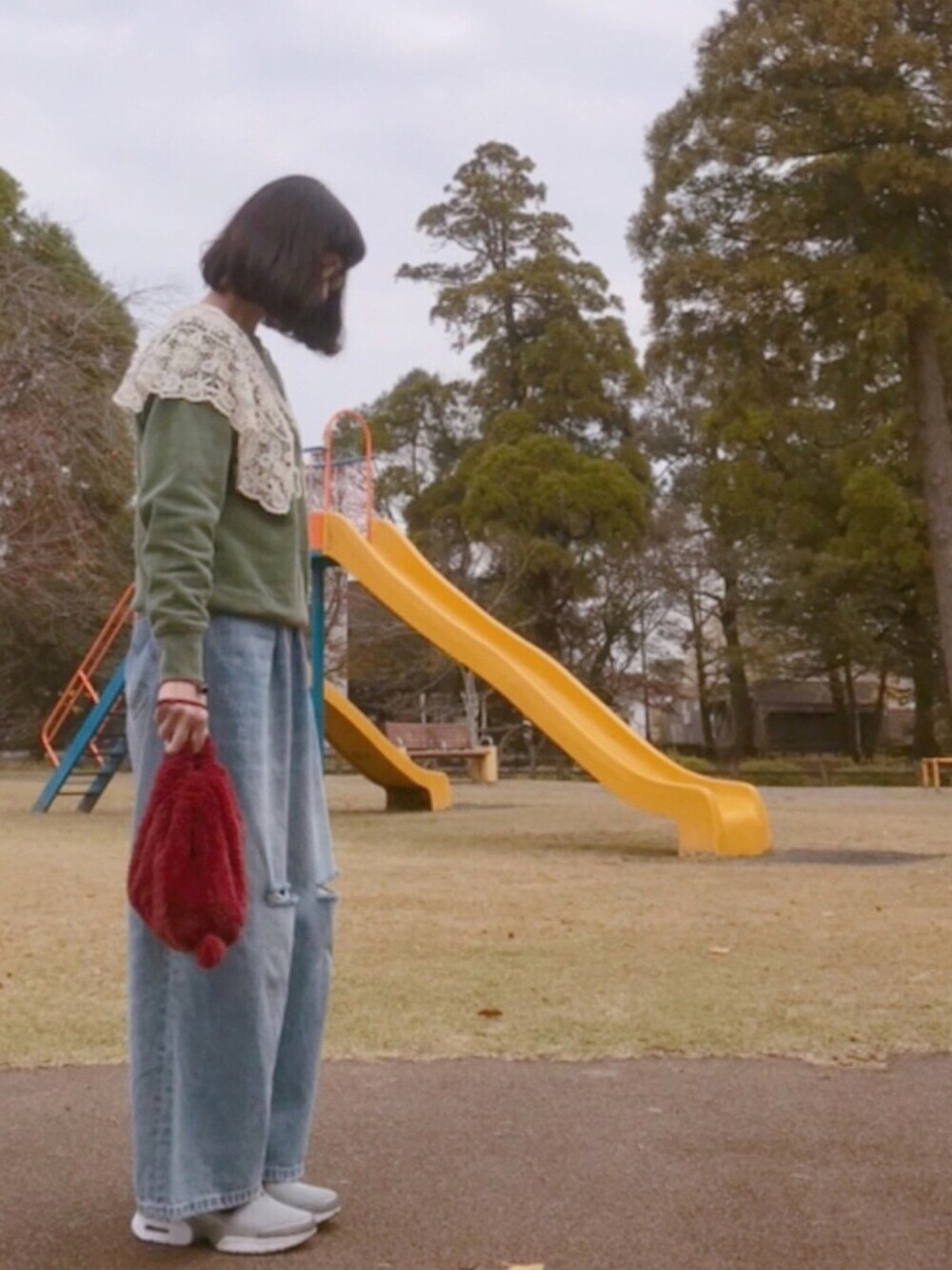 グリーン系のスウェット、ブルー系のデニムパンツ、シルバー系のスニーカーを着用したレディースの秋コーディネートの1枚目の写真