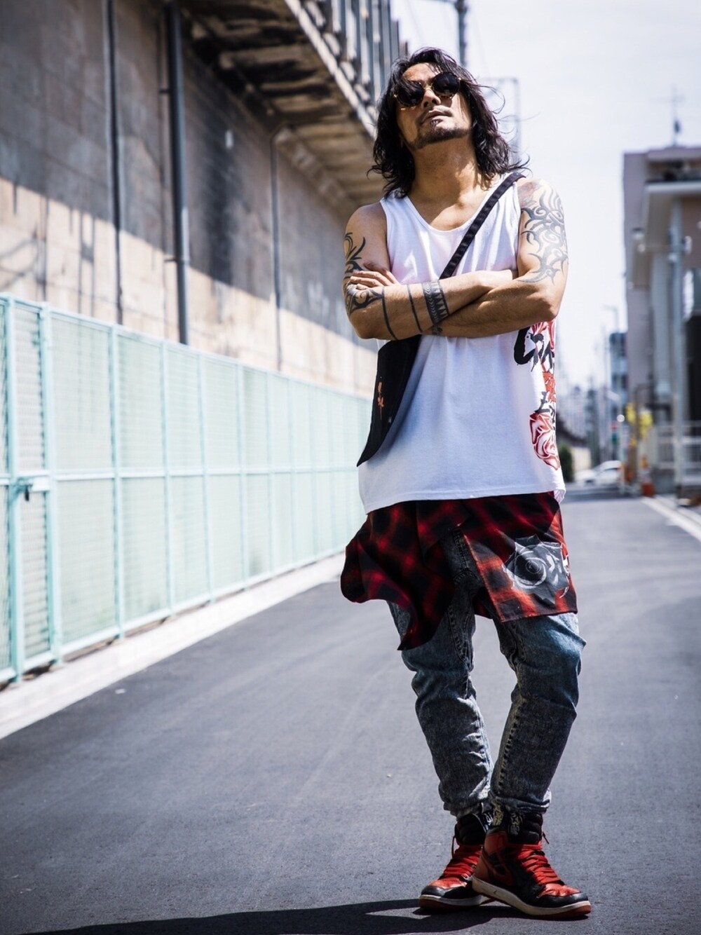 ホワイト系のタンクトップ、ブラック系のバッグ、レッド系のスカートを着用したメンズの夏コーディネートの1枚目の写真