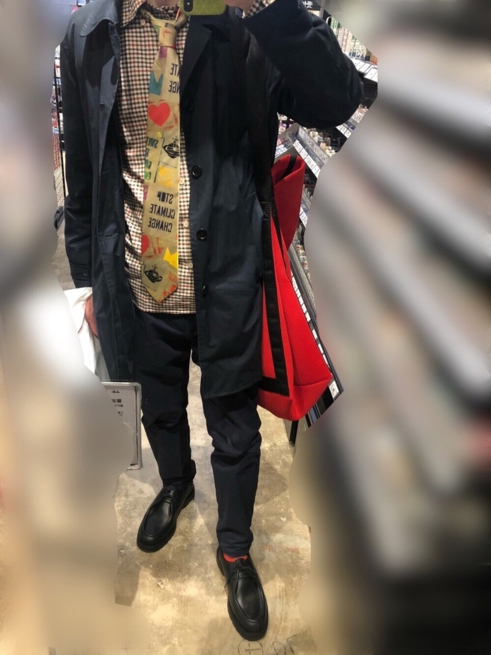 ブルー系のパンツ、ブラック系のドレスシューズ、レッド系のバッグを着用したメンズの冬コーディネートの1枚目の写真