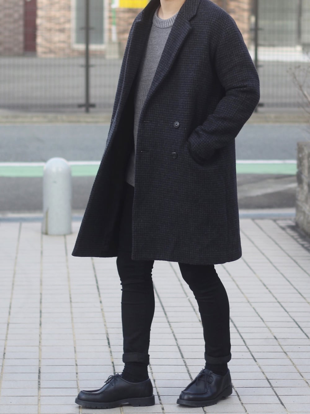 その他のチェスターコート、グレー系のニット/セーター、ブラック系のデニムパンツを着用したメンズの冬コーディネートの1枚目の写真