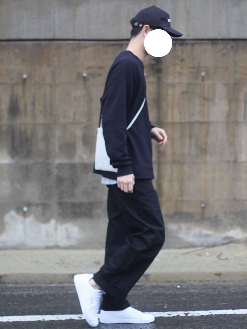 ブラック系のスウェット、グレー系のショルダーバッグ、ブラック系のチノパンツを着用したメンズの春コーディネートの1枚目の写真