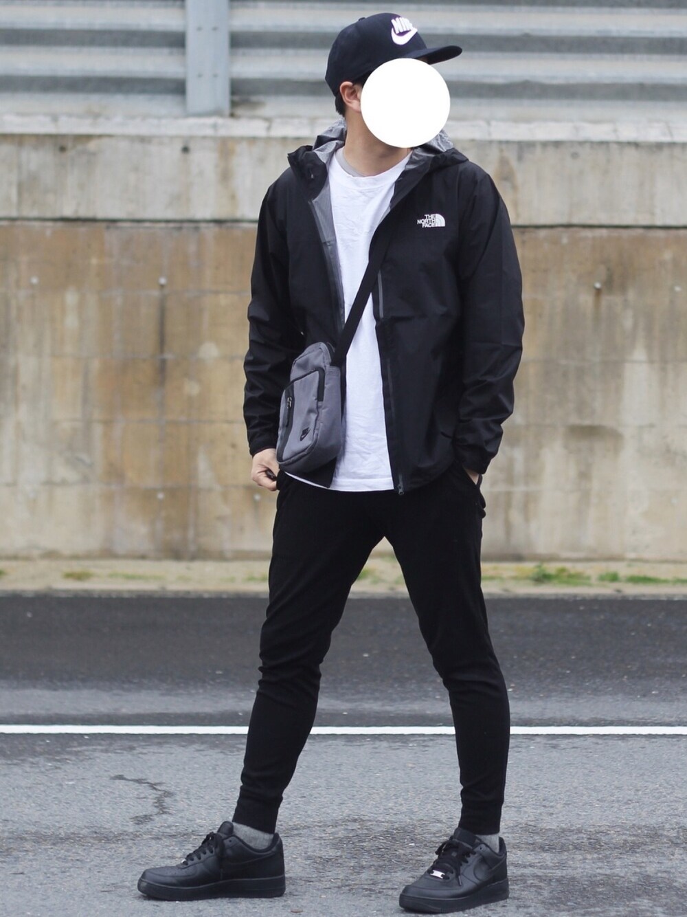ブラック系のマウンテンパーカー、ホワイト系のTシャツ/カットソー、ブラック系のスニーカーを着用したメンズの春コーディネートの1枚目の写真