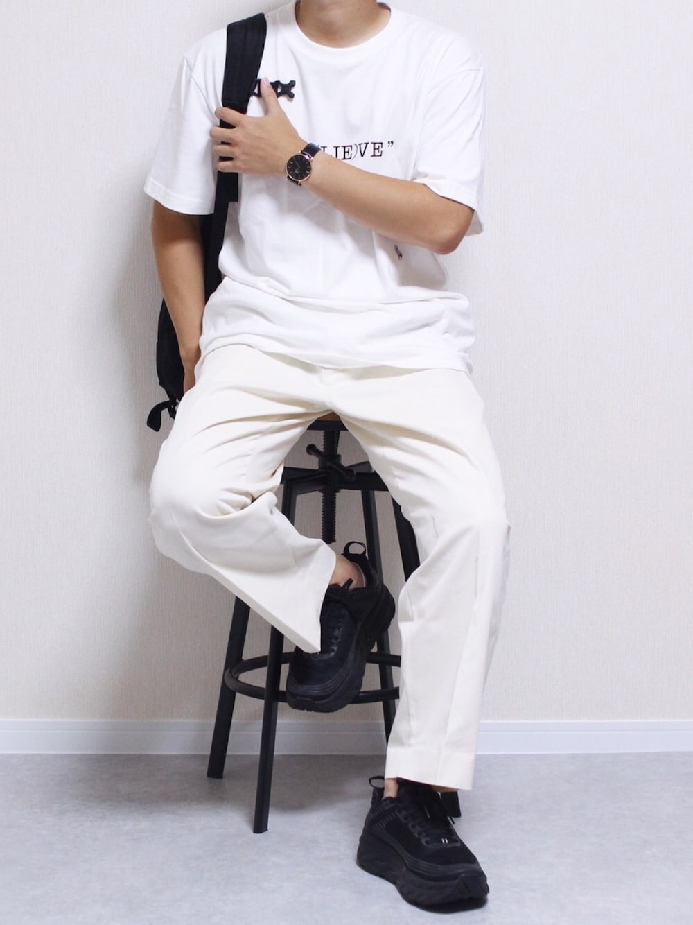 ホワイト系のTシャツ/カットソー、ブラック系のスニーカー、ホワイト系のチノパンツを着用したメンズの秋コーディネートの1枚目の写真