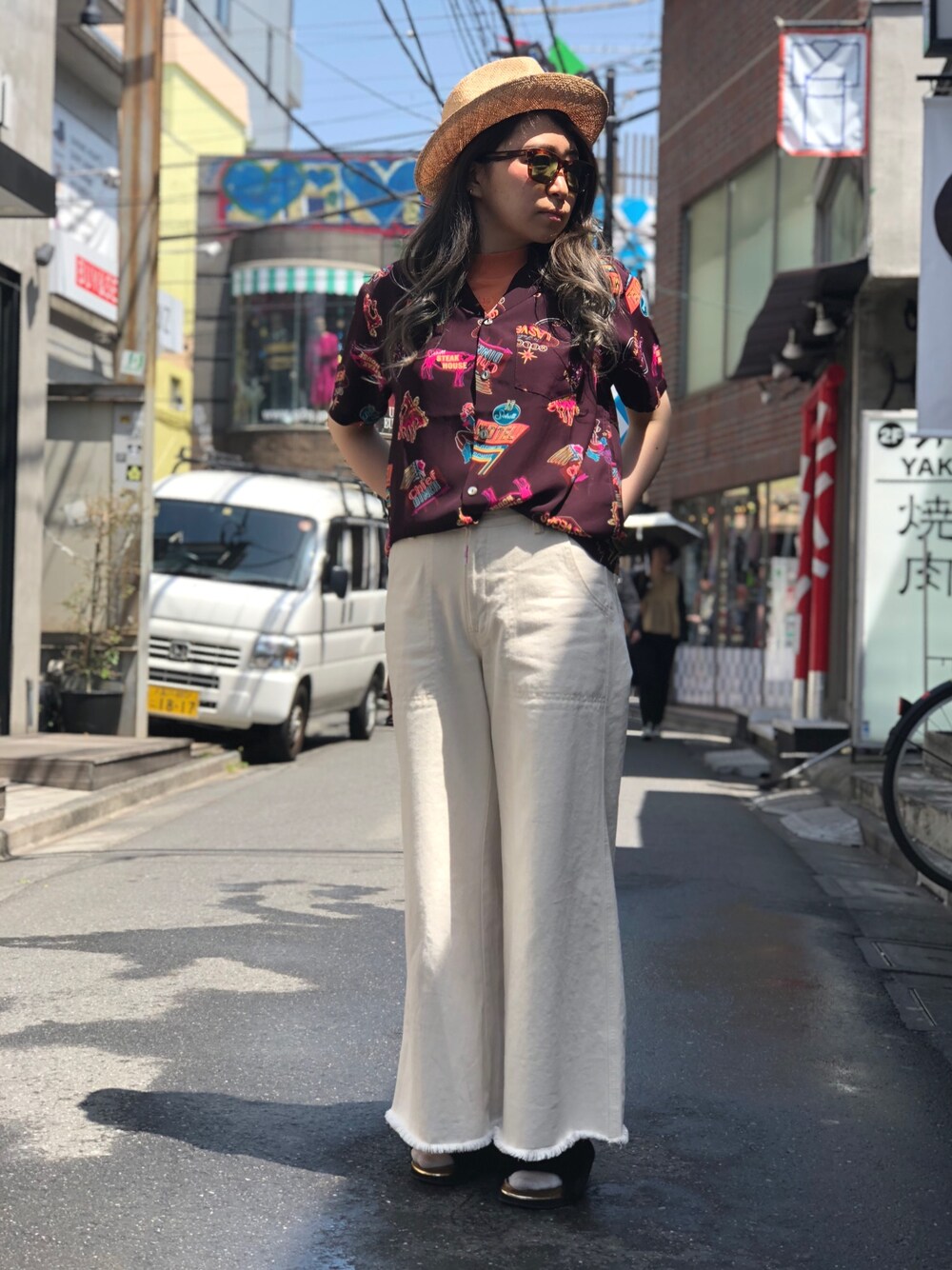 レッド系のシャツ/ブラウス、ブラウン系のサングラス、ベージュ系のハットを着用したレディースの春コーディネートの1枚目の写真