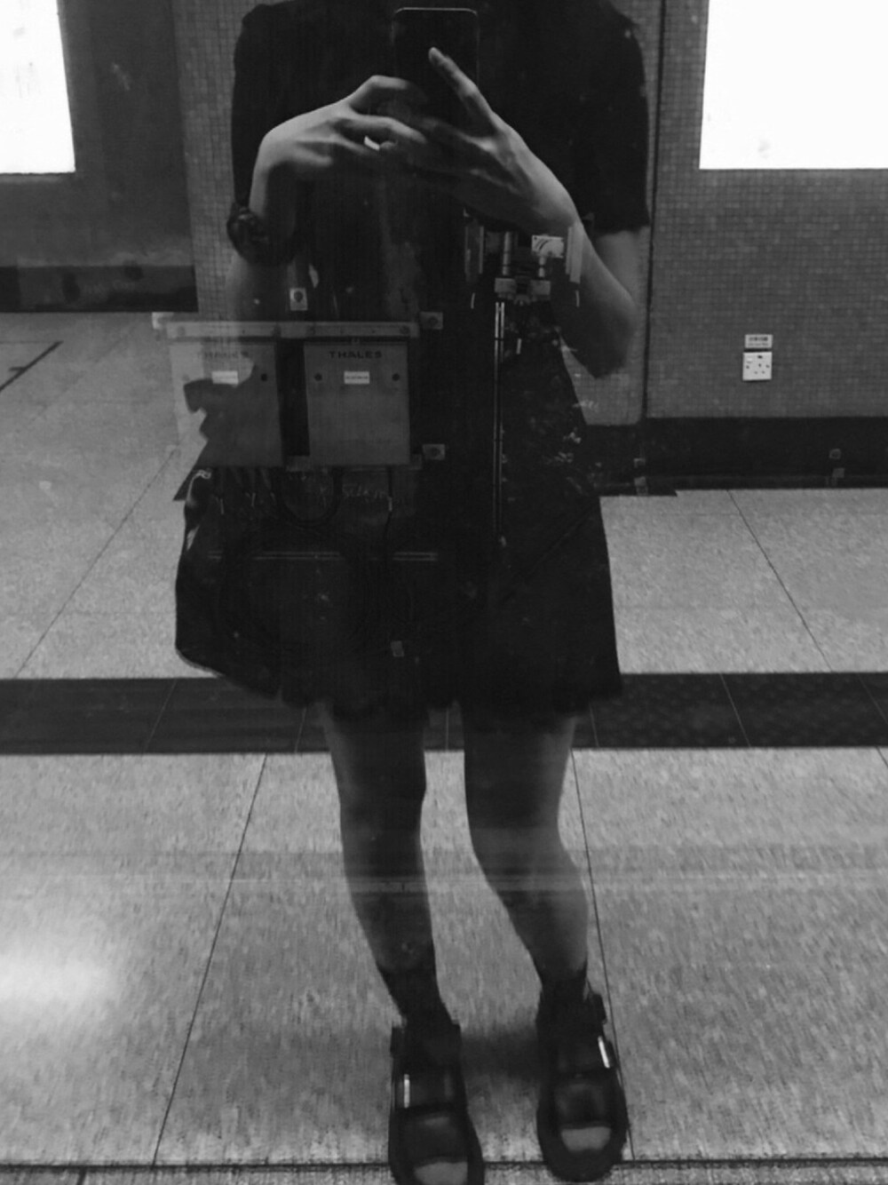 ブラック系のチュニック、ブラック系のサンダル、ブラック系のショルダーバッグを着用したレディースの夏コーディネートの1枚目の写真