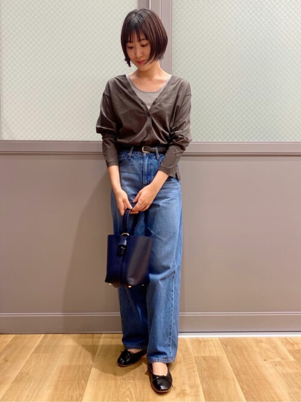 グリーン系のカーディガン/ボレロ、グレー系のタンクトップ、ブルー系のデニムパンツを着用したレディースの秋コーディネートの1枚目の写真