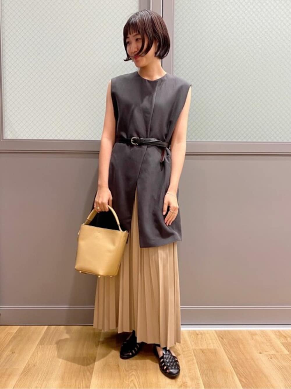 グレー系のワンピース、グレー系のタンクトップ、ベージュ系のスカートを着用したレディースの秋コーディネートの1枚目の写真