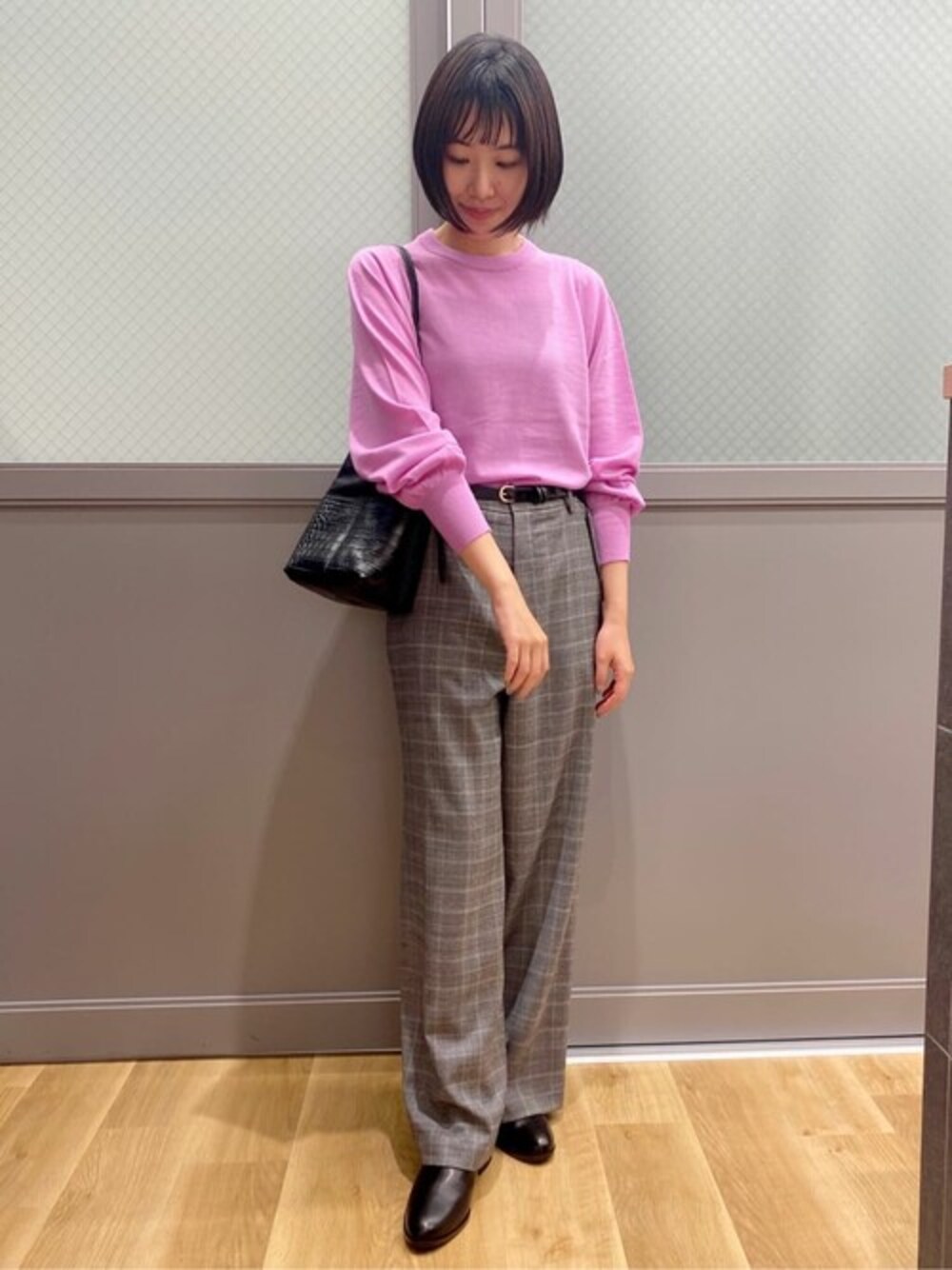 ピンク系のニット/セーター、グレー系のその他パンツ、ブラック系のハンドバッグを着用したレディースの秋コーディネートの1枚目の写真