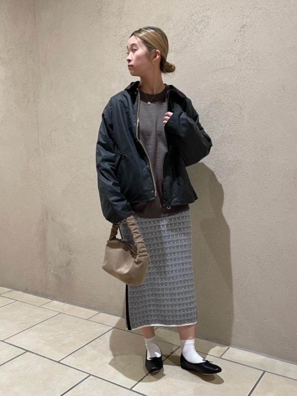 ブラック系のバレエシューズ、ブラック系のスカート、ブラウン系のショルダーバッグを着用したレディースの冬コーディネートの1枚目の写真